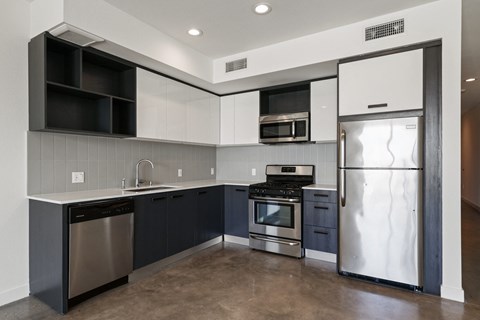 a kitchen with stainless steel appliances and black and white cabinets