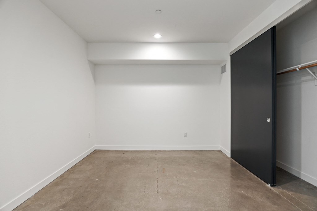 Bedroom with Recessed Lighting, Polished Concrete Flooring, and Closet