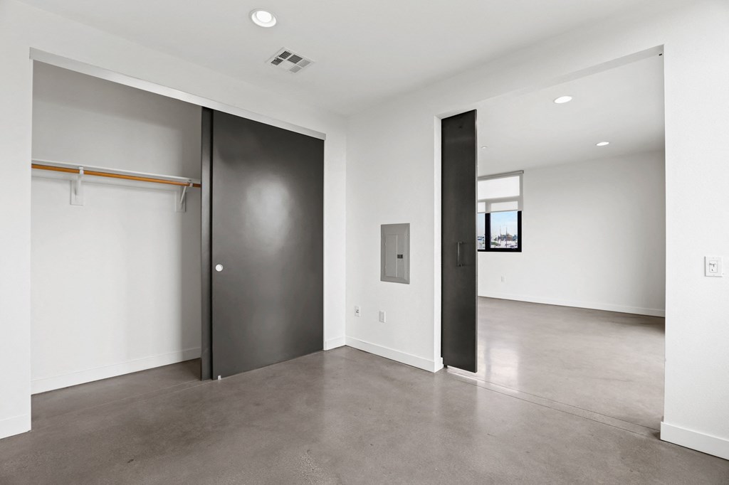 Bedroom withSliding Door, Large-Size Closet, and Concrete Flooring