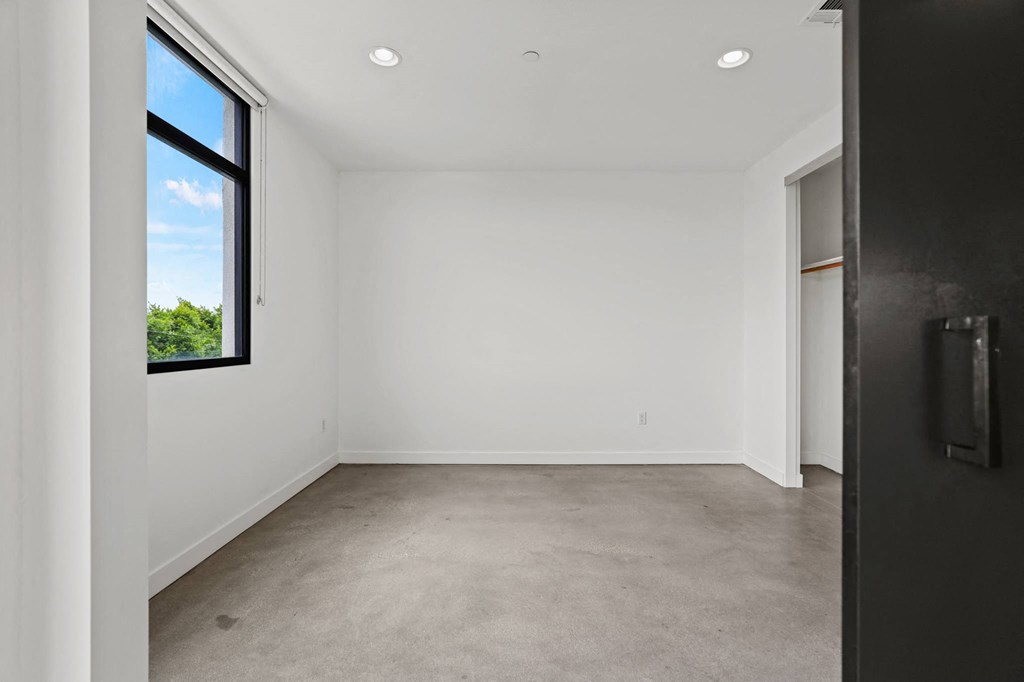 Bedroom with Concrete Flooring, Recessed Lighting, Large Windows