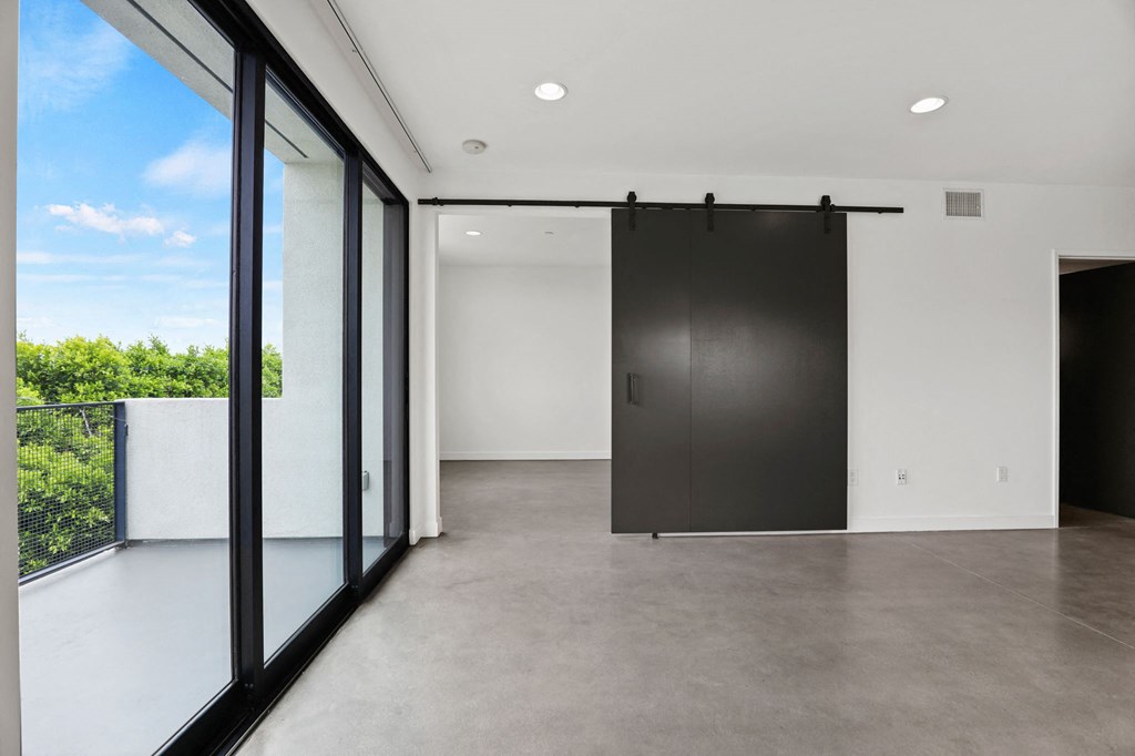 Living Room with Spacious Patio, Concrete Flooring, and Recessed Lighting