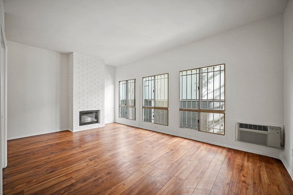 A room with a fireplace and wood floors.