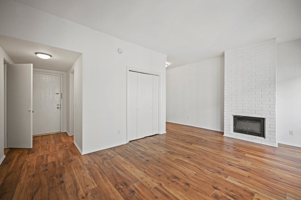 A room with a fireplace and wood floors.