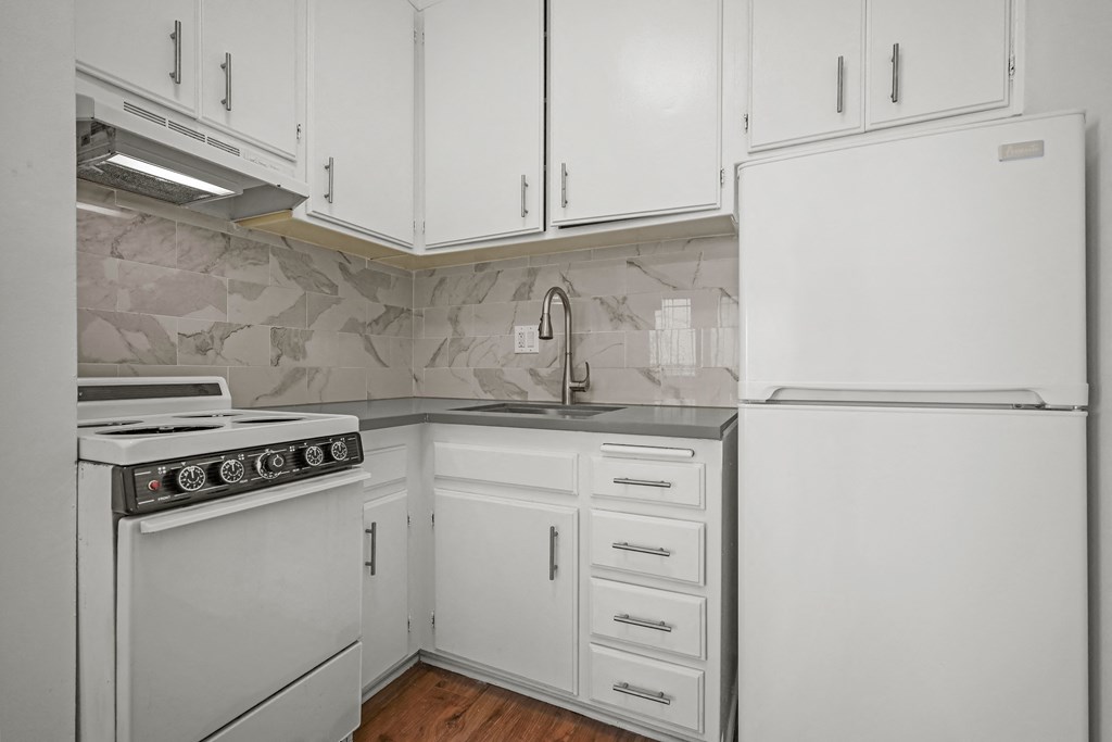 A kitchen with white appliances and cabinets.