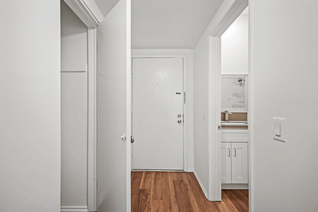 A white door is in the middle of a hallway.
