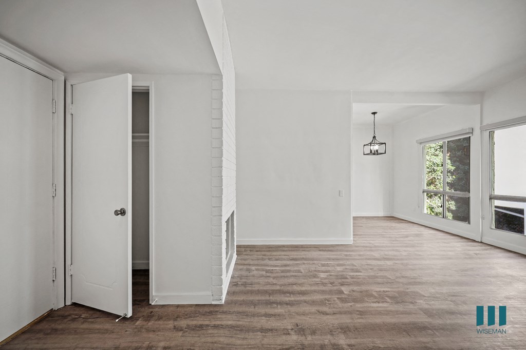 A room with a white door and a brown carpet.