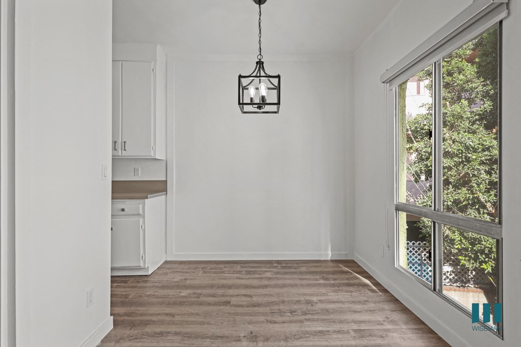 A room with a wooden floor and a hanging light fixture.