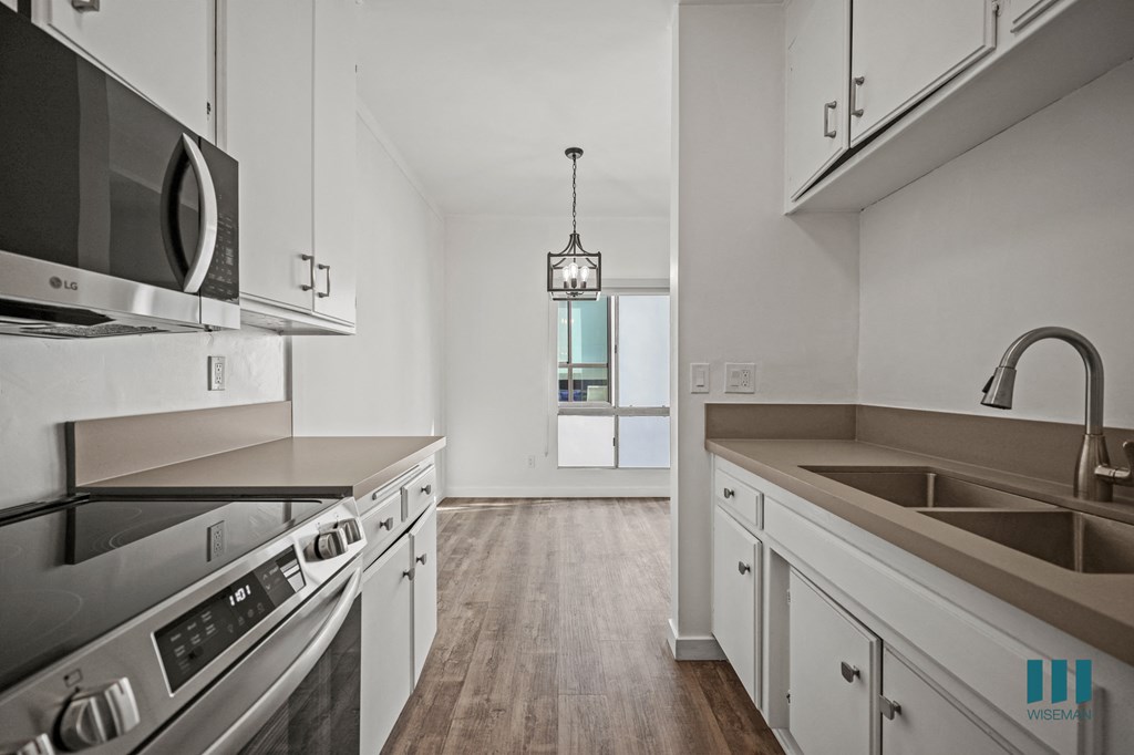 A modern kitchen with stainless steel appliances and white cabinets.