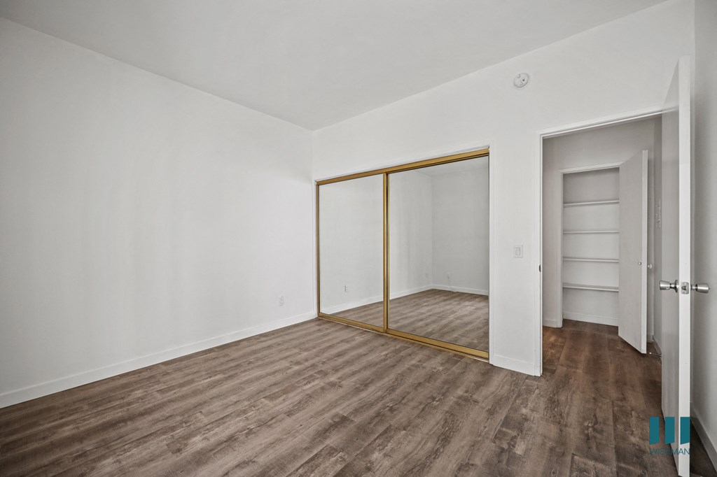 A room with a white wall and a wooden floor.