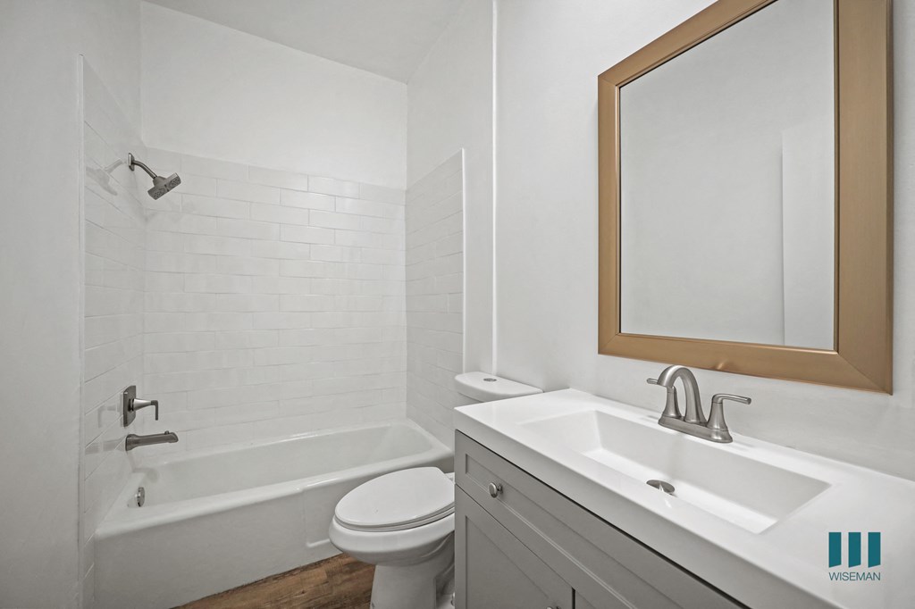 A white bathroom with a toilet, sink, and tub.