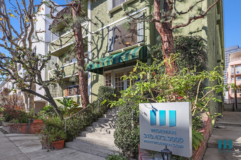 A green building with a sign in front that says "Wise 310.473.3000".