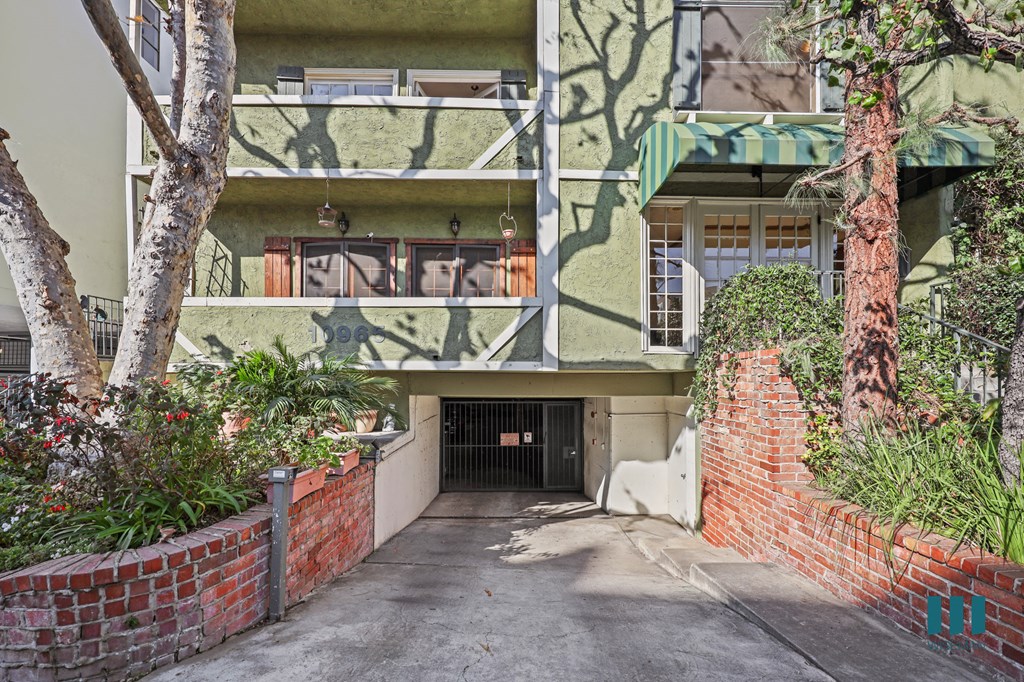 A green building with a tree in front of it.
