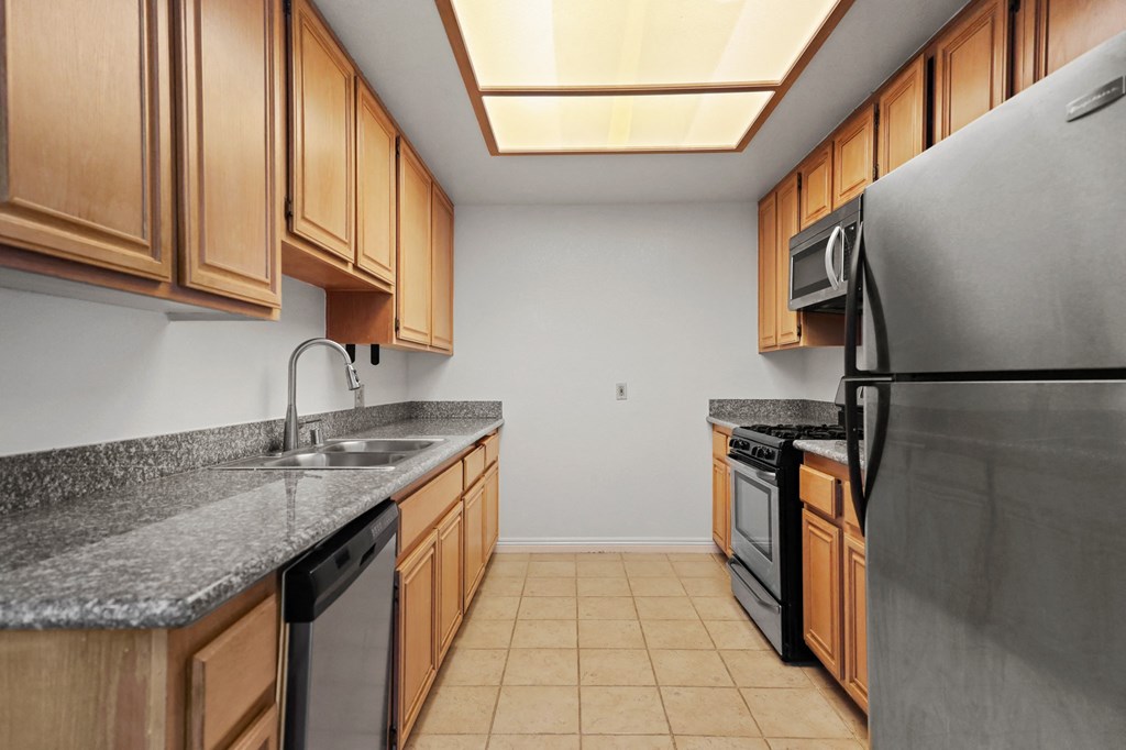 a kitchen with wood cabinets and stainless steel appliances and granite counter tops