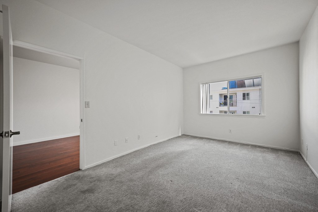 an empty room with white walls and a window