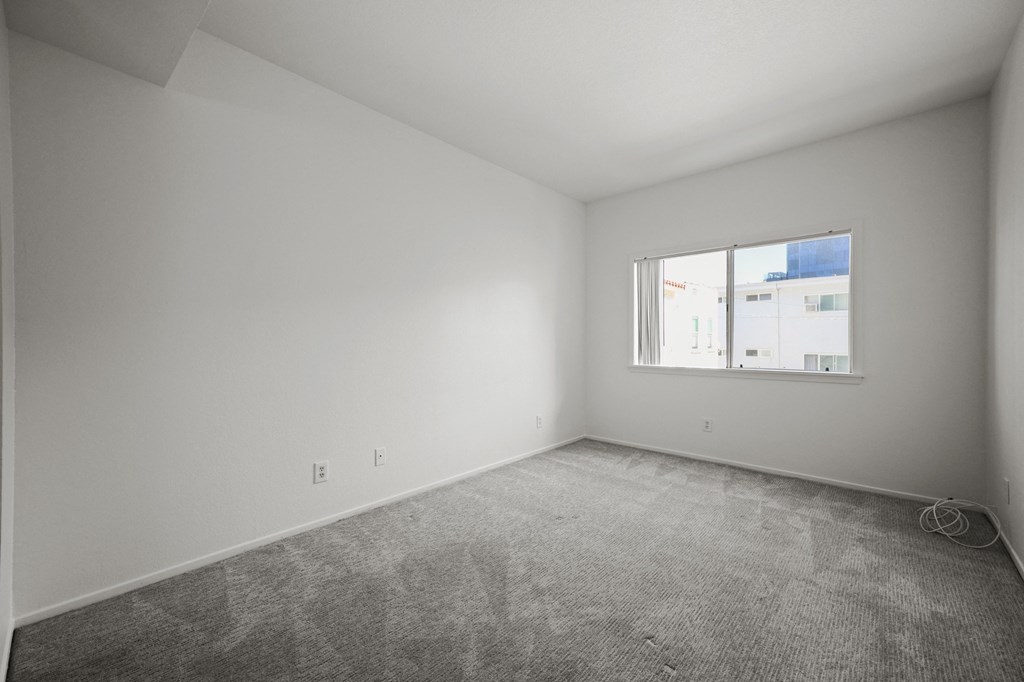 an empty room with a window in a white house
