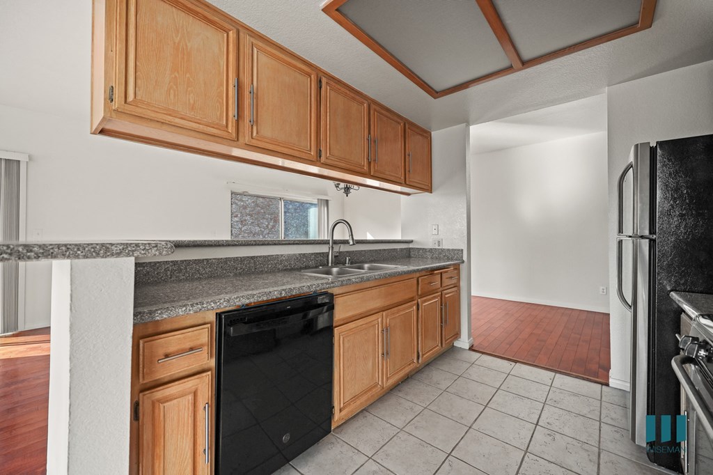 A kitchen with black appliances and wooden cabinets.