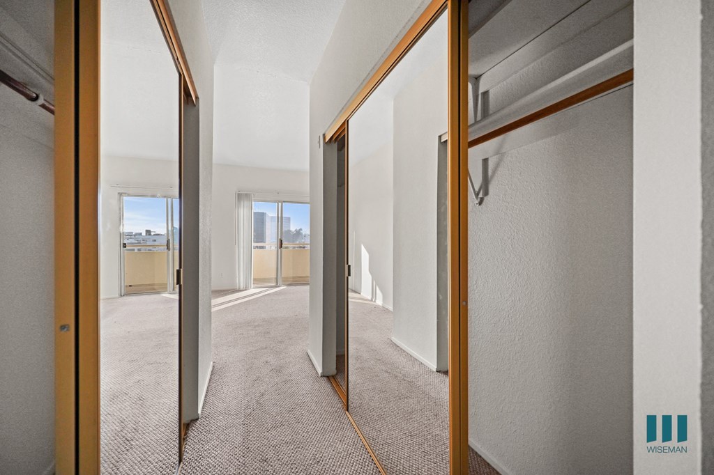 A hallway with a carpeted floor and white walls.