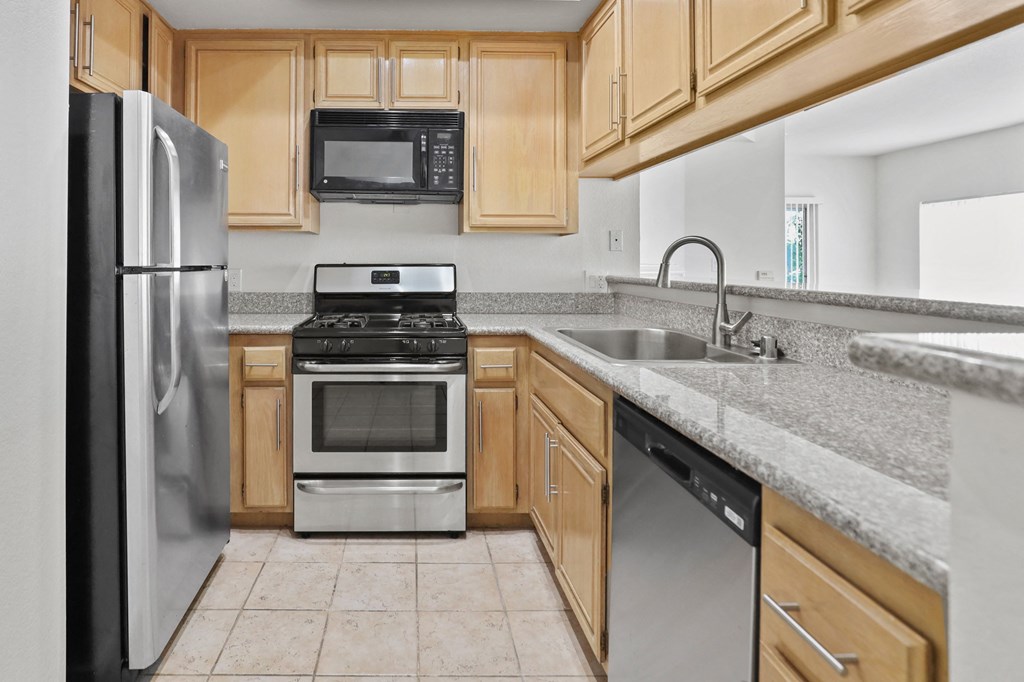 a kitchen with wooden cabinets and stainless steel appliances
