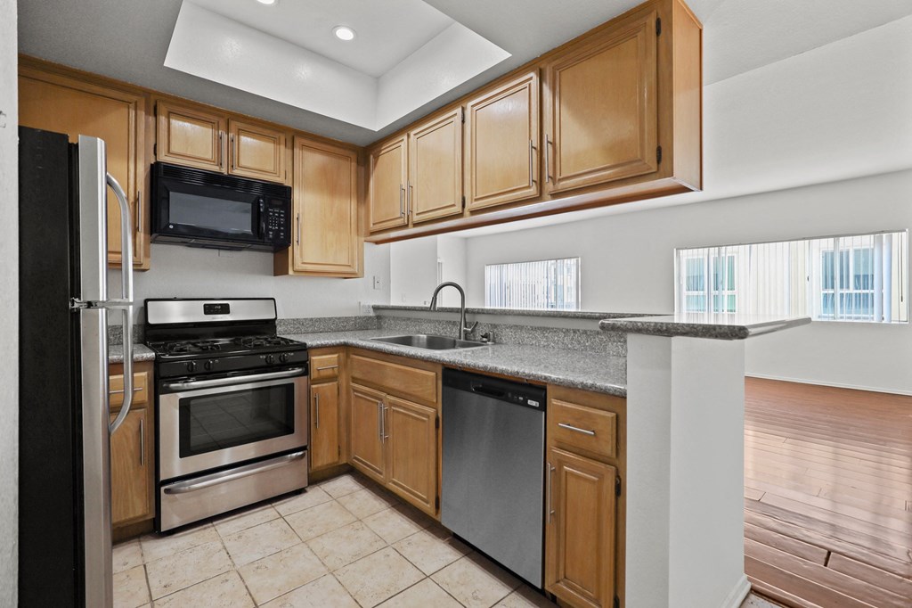 a kitchen with wooden cabinets and stainless steel appliances