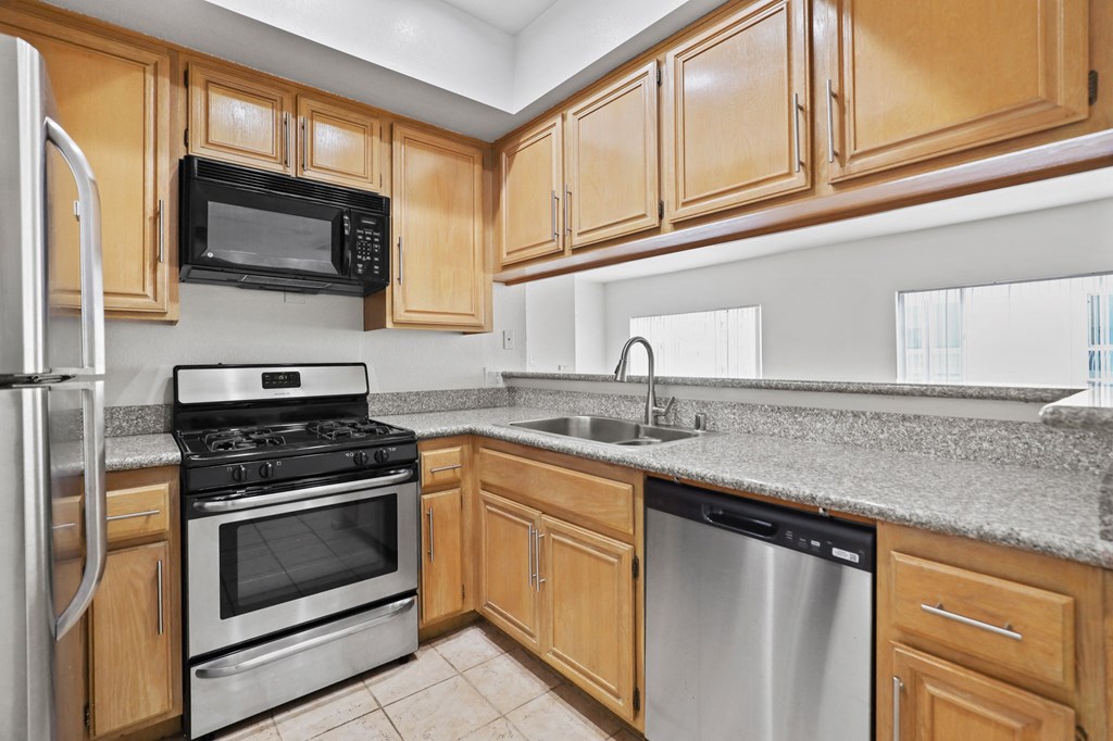 a kitchen with wooden cabinets and stainless steel appliances