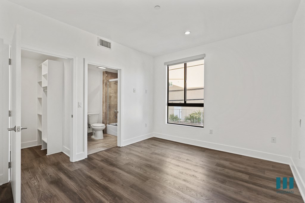 Bedroom with Bathroom, Vinyl Flooring, and Windows