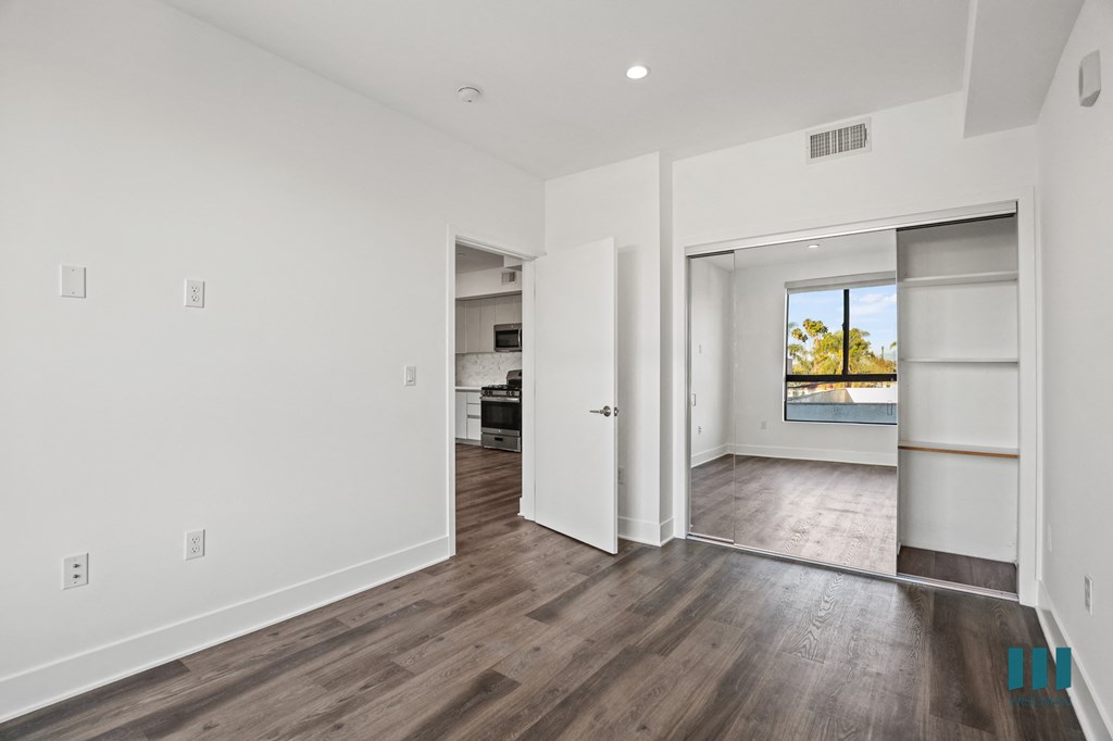 Bedroom with Mirrored Closet with Built-In Shelving