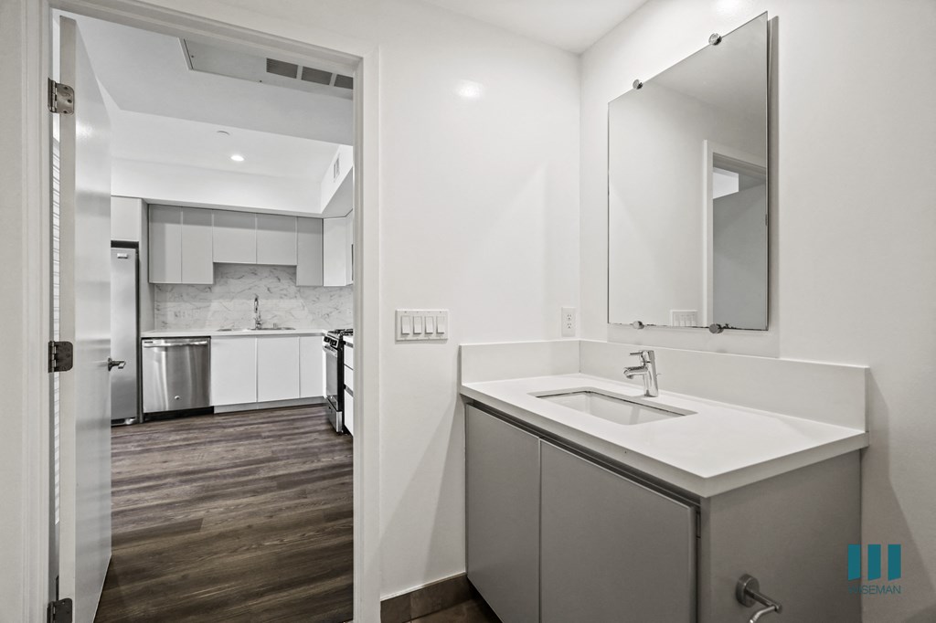 a white kitchen with a sink and a mirror