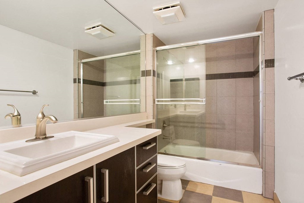 Bathroom with Bathtub with Glass Doors and Cabinet Storage