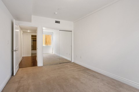 the living room and dining room of a house with white walls and carpet