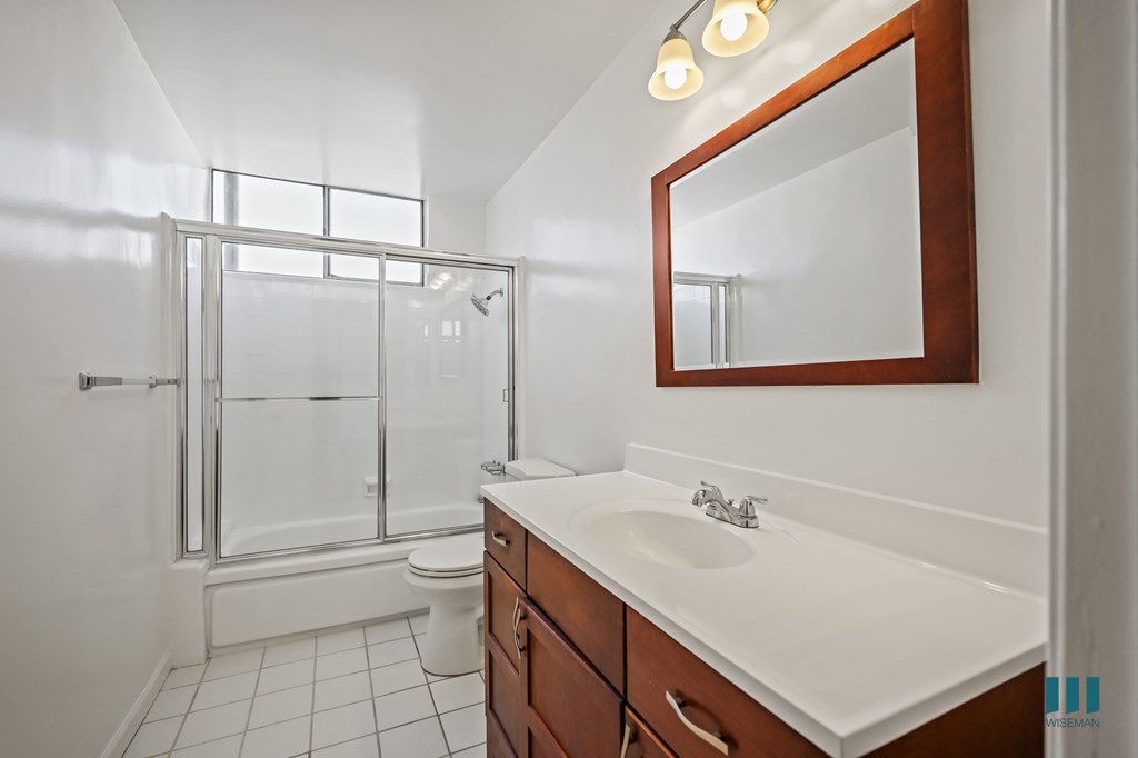 Bathroom with a Shower-Bath with a Glass Door and VAnity Cabinet Storage and Drawers
