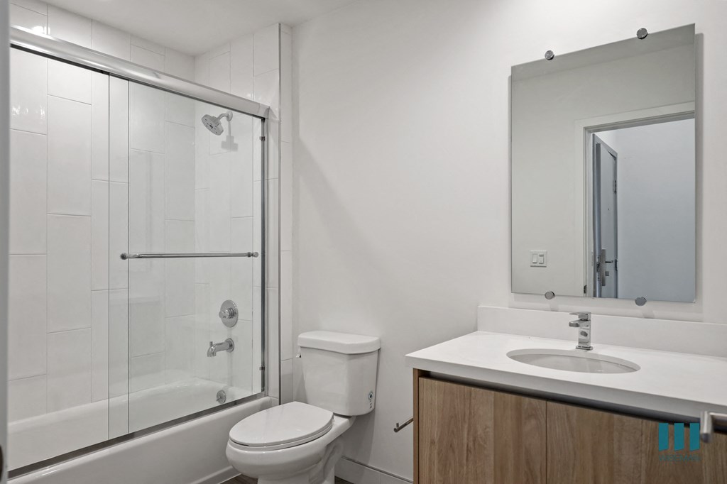 a white bathroom with a shower sink and toilet