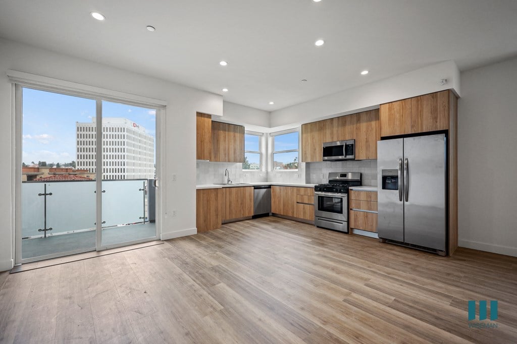 a large kitchen with stainless steel appliances and a city view