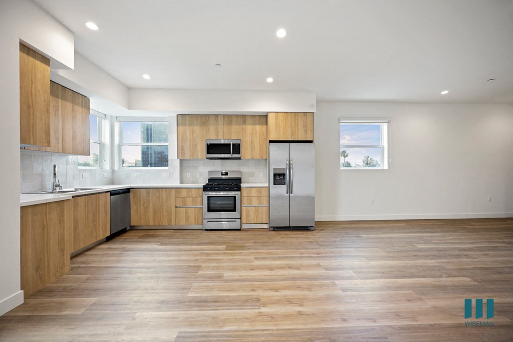 a kitchen with a geometric design on the wall and wood floors