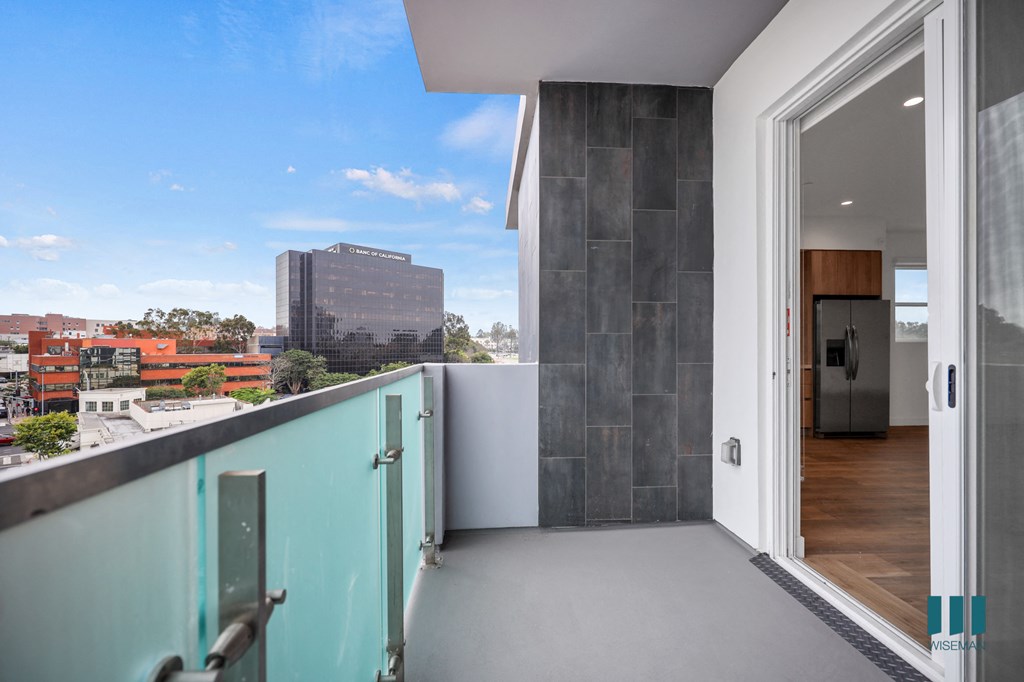 a balcony with a door and a city in the background