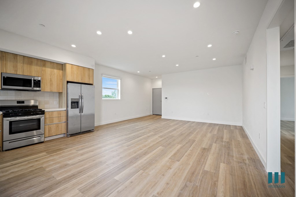 a kitchen and living room with wood floors and white walls