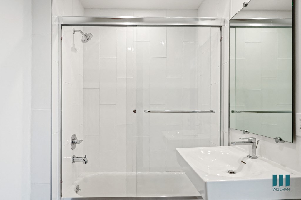 a white bathroom with a shower and a sink