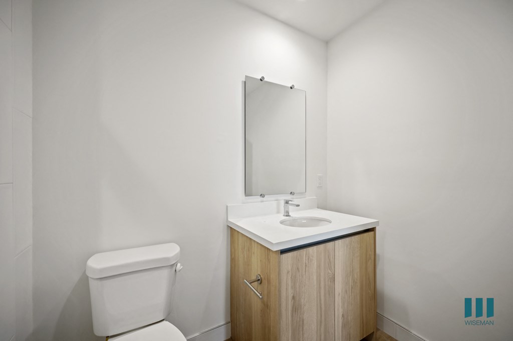 a bathroom with a toilet sink and mirror