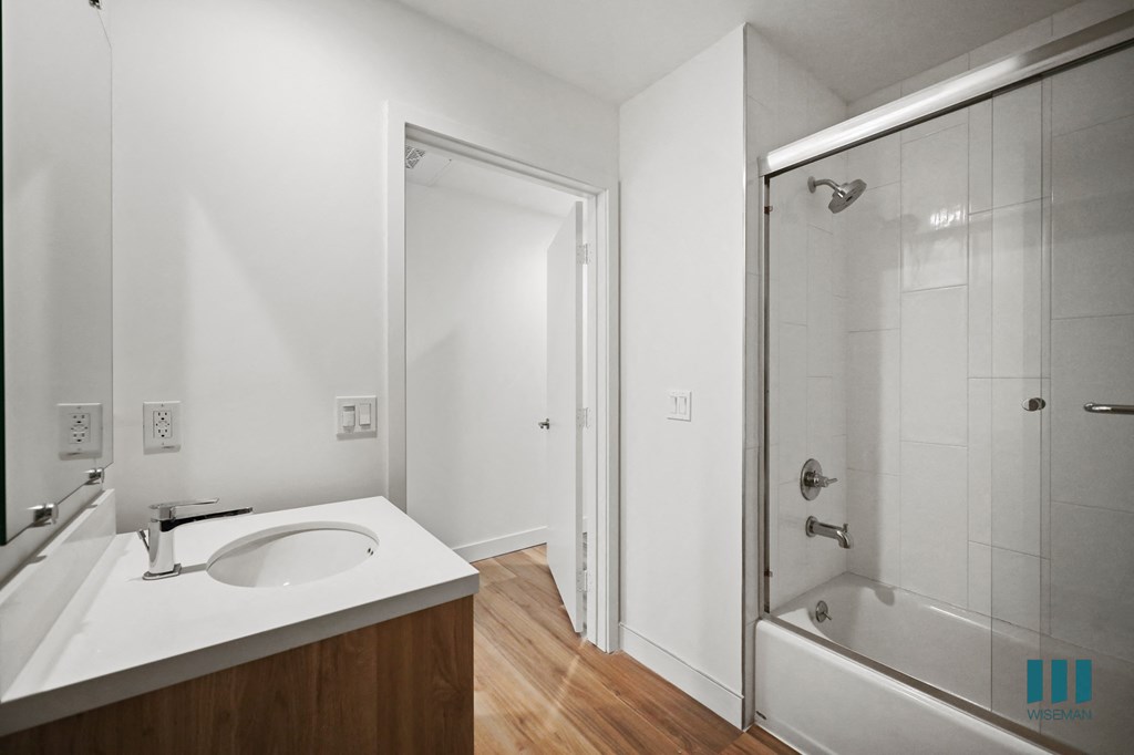 a bathroom with a sink and a shower and a mirror