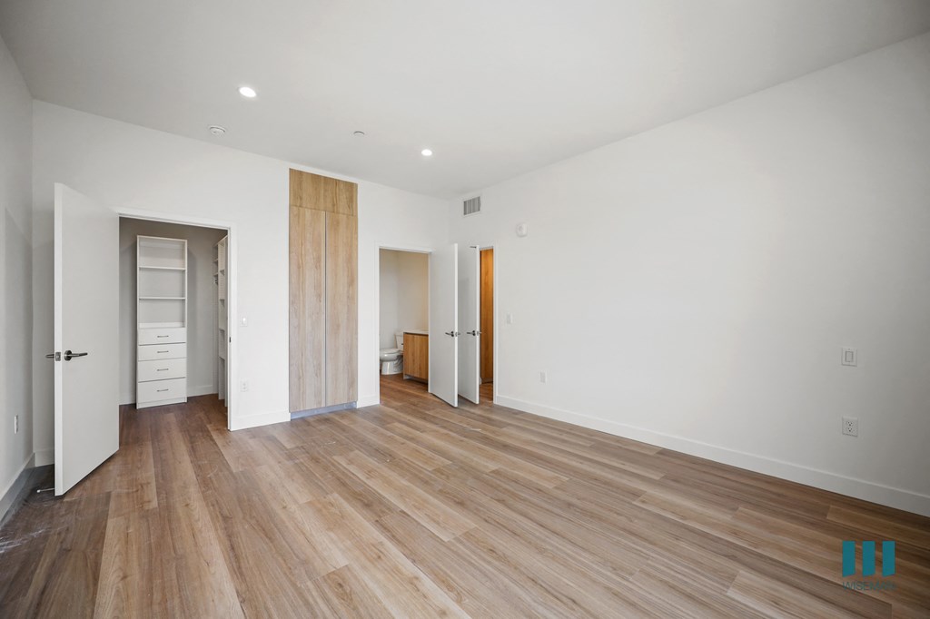 a renovated living room with white walls and wood floors