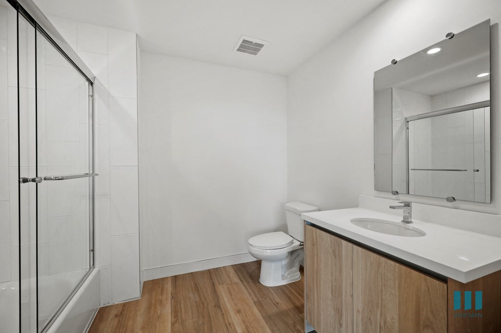 a bathroom with a toilet and a sink and a shower