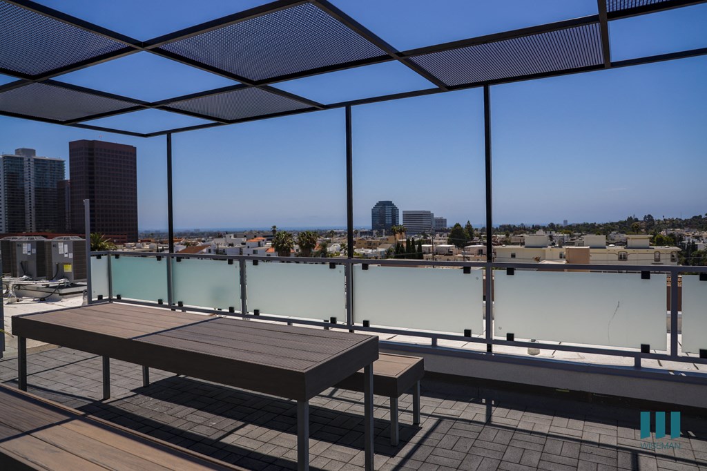 a view of the city from a rooftop terrace with a table and benches