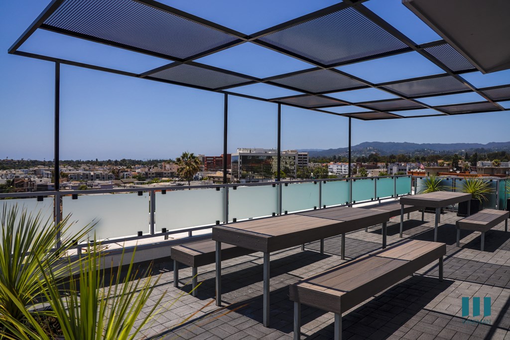 a deck with benches and tables overlooking a body of water