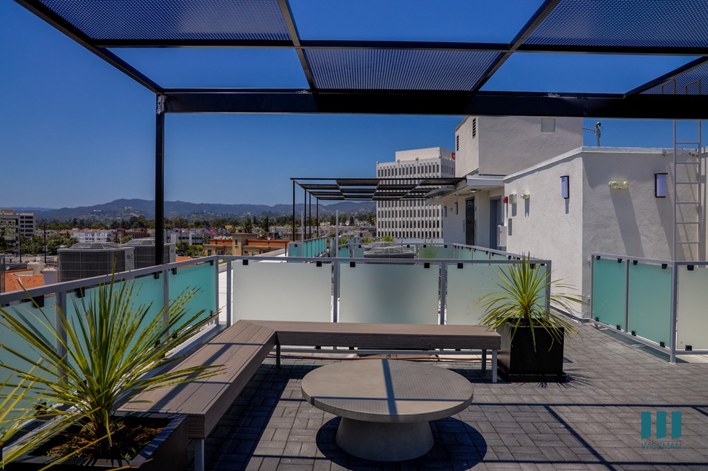 a roof terrace with a table and a view of the city