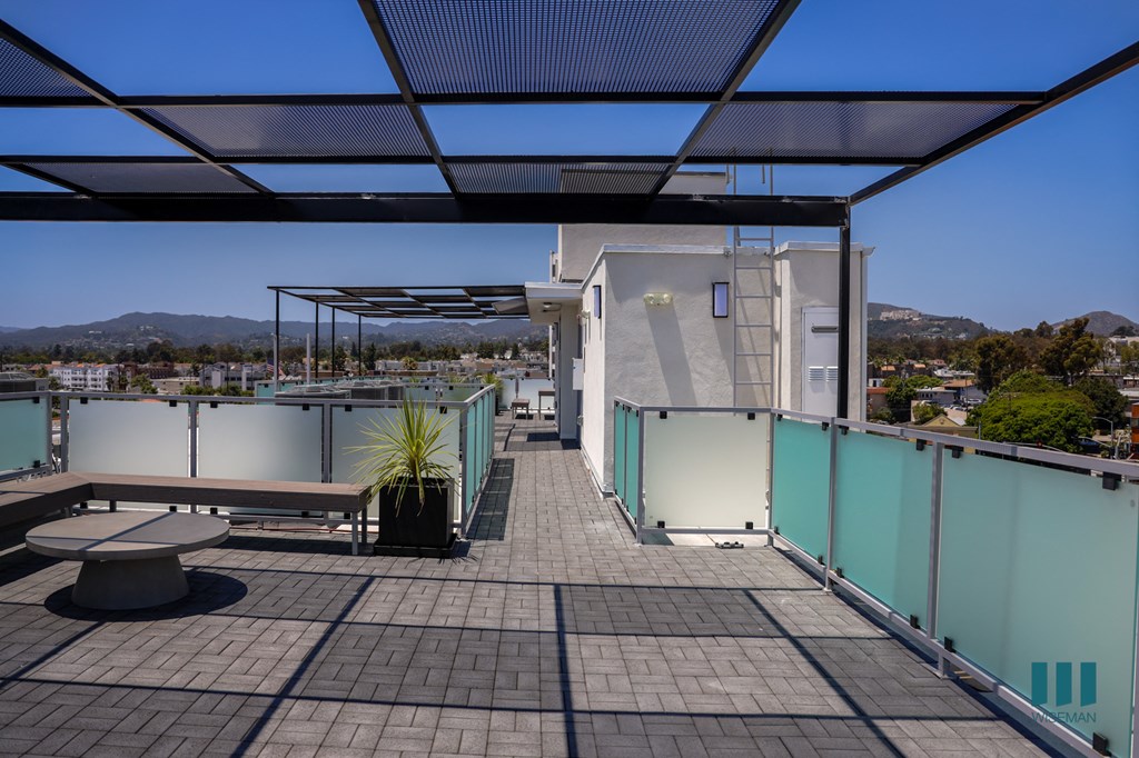 a roof terrace with a view of a city and a blue sky