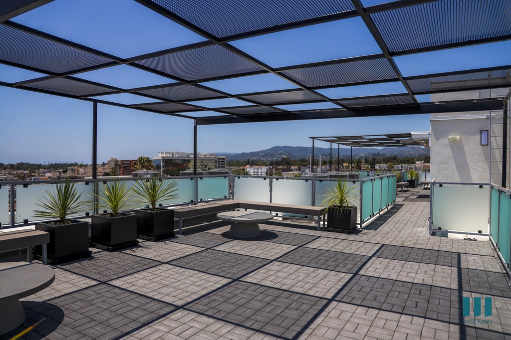 a roof terrace with tables and chairs and a view of a city and a