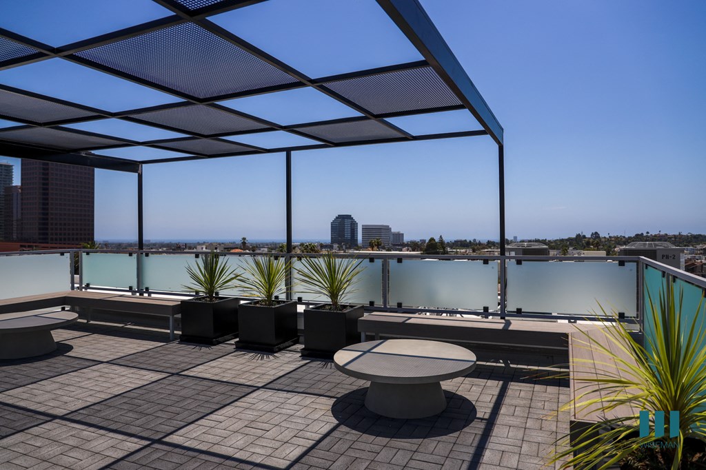 a roof terrace with a view of the city and a table and chairs