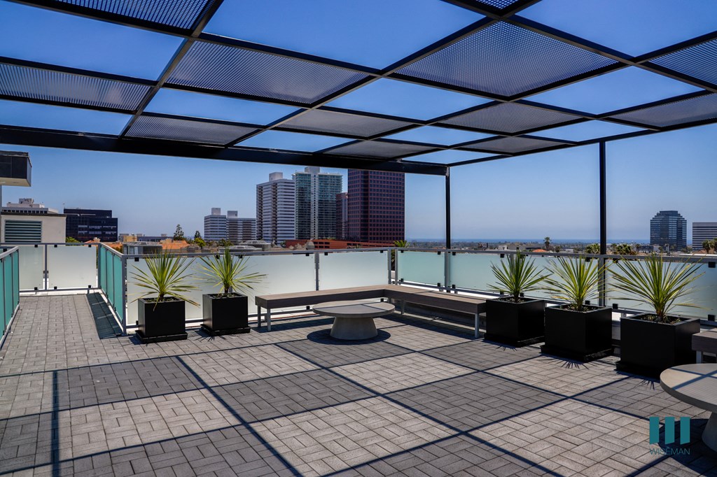 a roof terrace with a view of the city and a bench