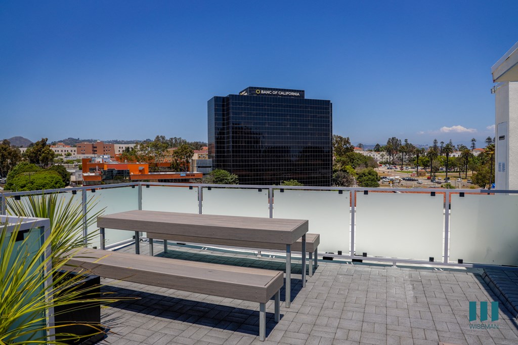 a roof deck with two benches and a view of the city