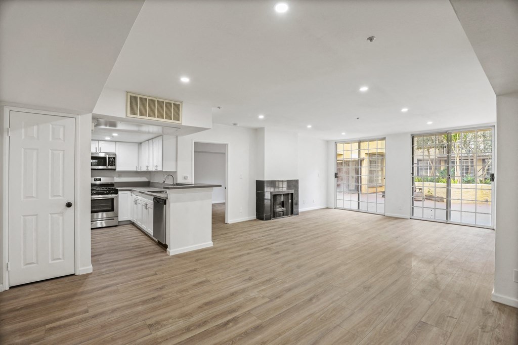 Open-Concept Floor Plan with Electric Fireplace, Recessed Lighting, Vinyl Flooring, and Lots of Windows with Natural Light