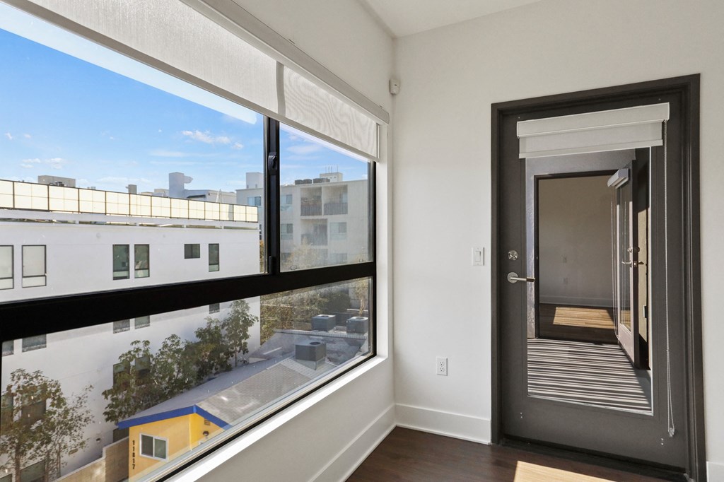 Living Room with Large Windows with Shades and Patio